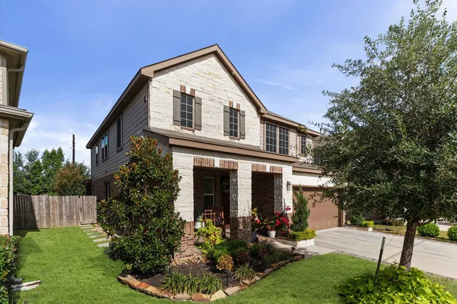 a front view of a house with a yard and trees