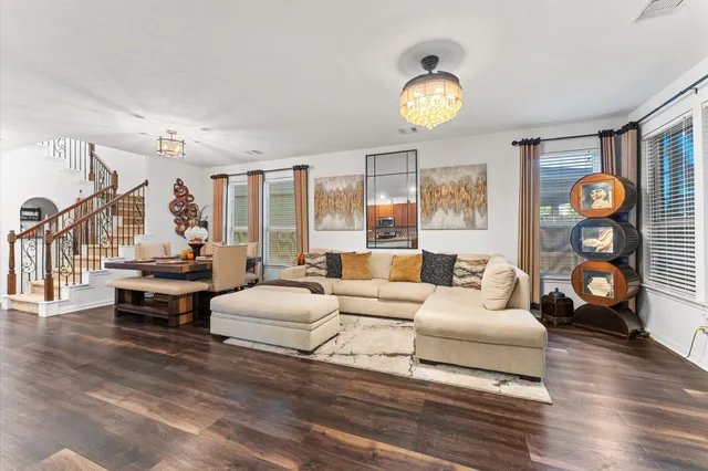 a living room with furniture a chandelier and a table