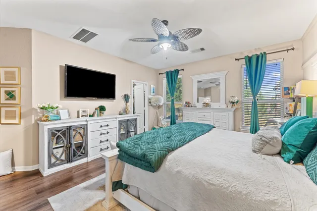 a spacious bedroom with a bed and a flat screen tv