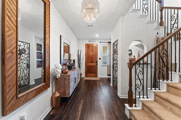 a view of a hallway with wooden floor and staircase