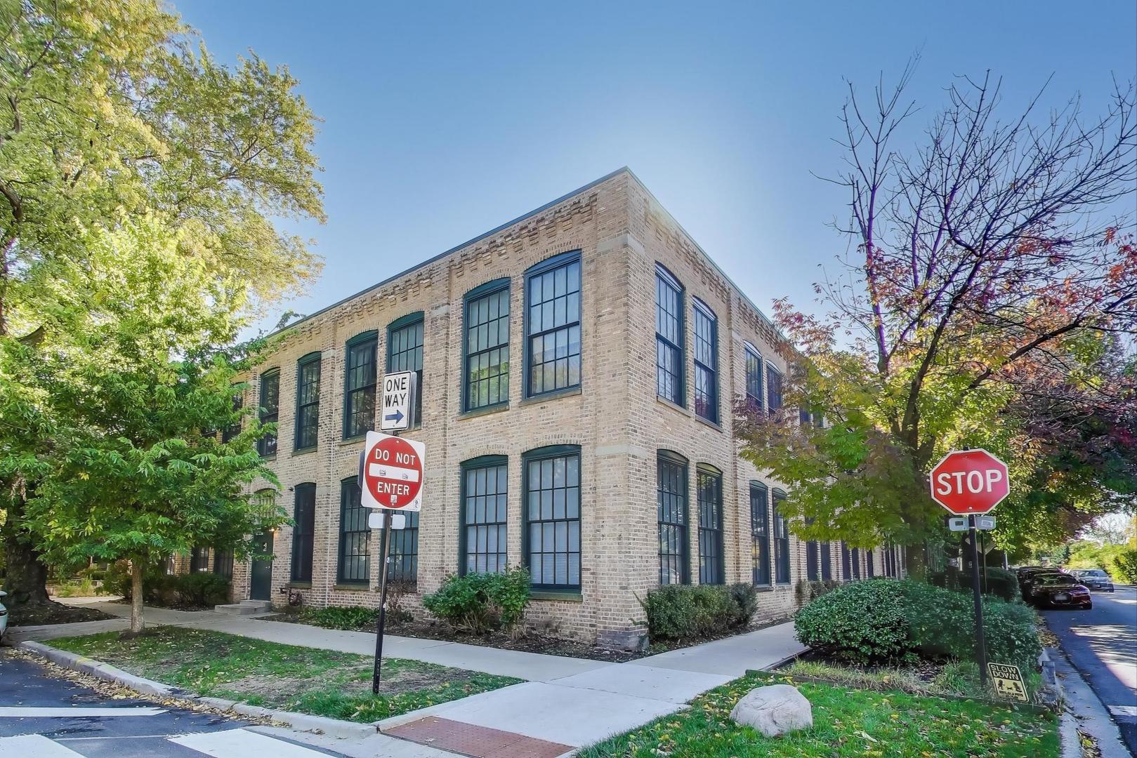 5235 North Ravenswood Avenue, Unit 3 Chicago, IL 60640 - Photo 23 of 27 a front view of multi story residential apartment building with yard and sign board