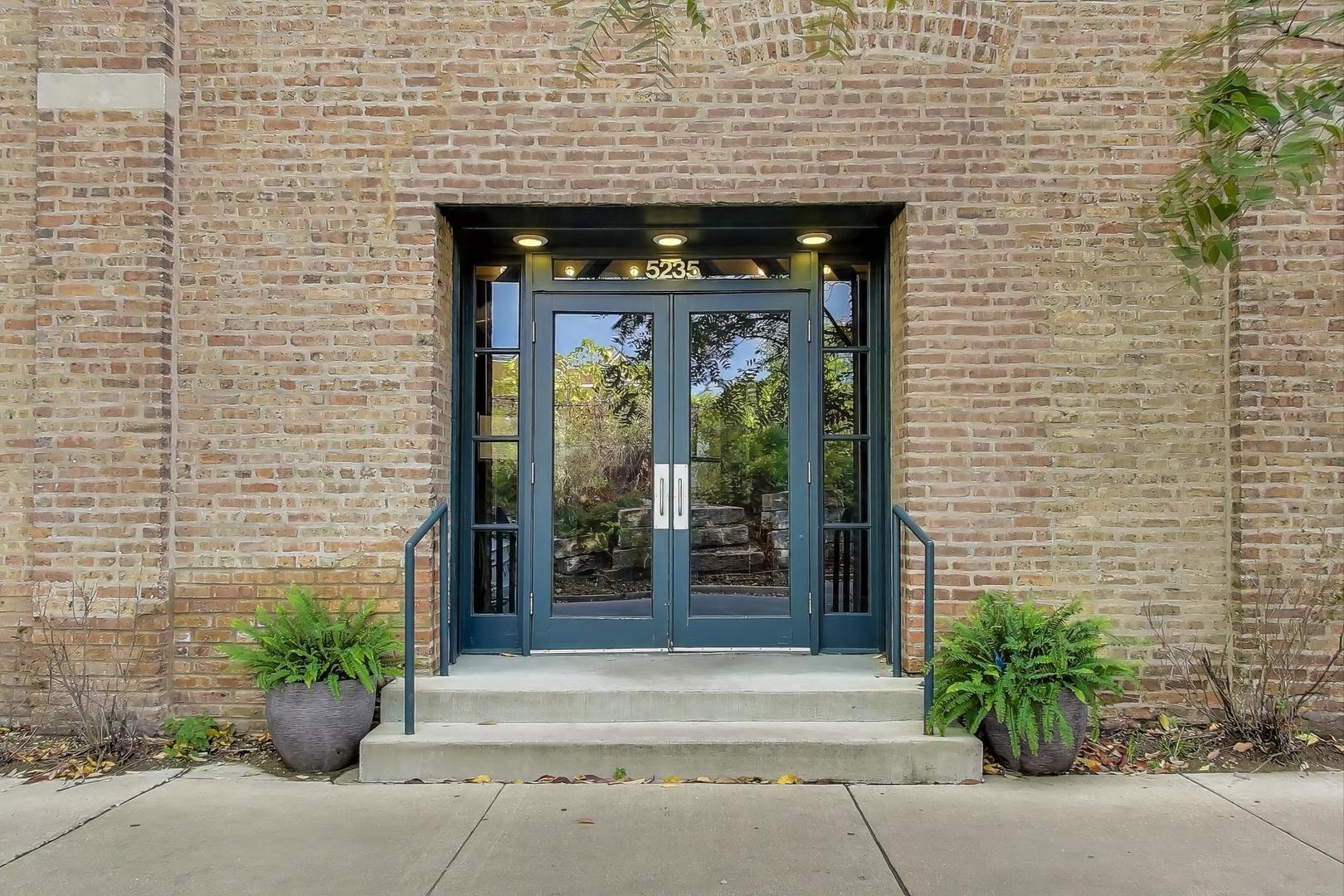 5235 North Ravenswood Avenue, Unit 3 Chicago, IL 60640 - Photo 3 of 27 a front view of a building with potted plants