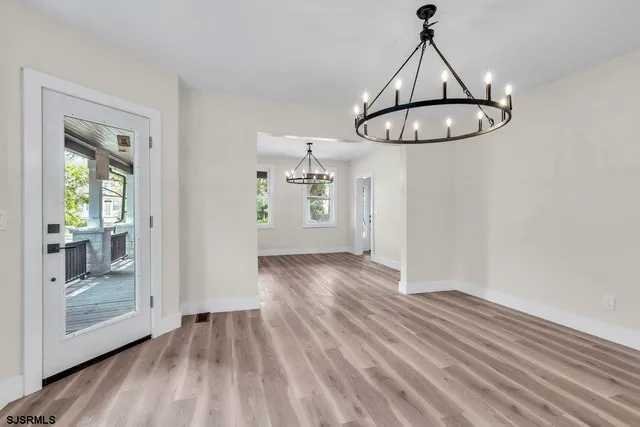a view of empty room with wooden floor and window