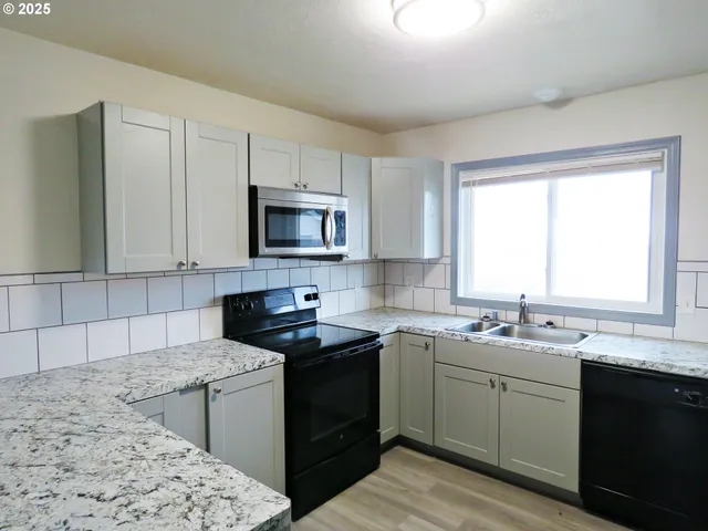 a kitchen with a sink stove top oven and microwave