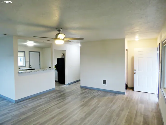 a view of a big room with wooden floor and windows