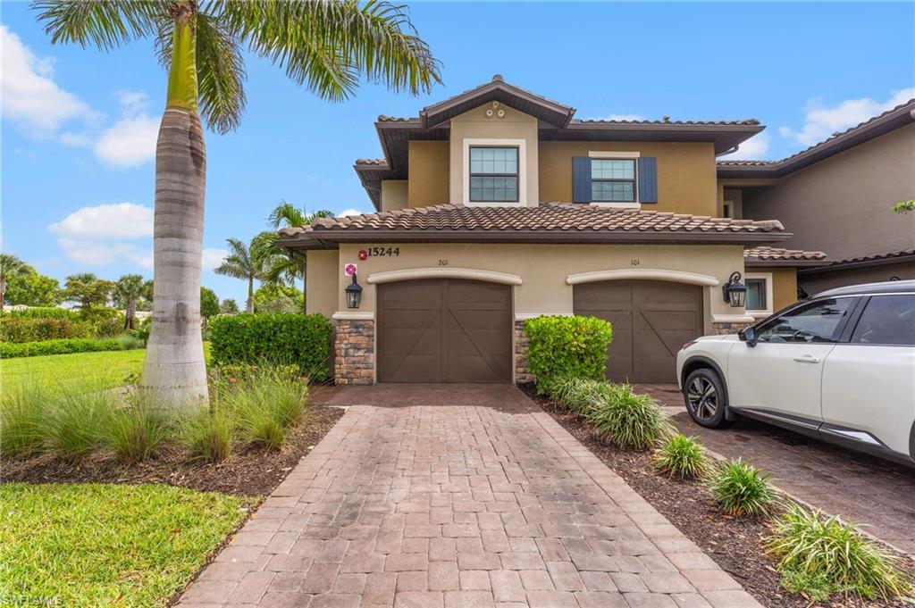 a front view of a house with a garden and palm trees