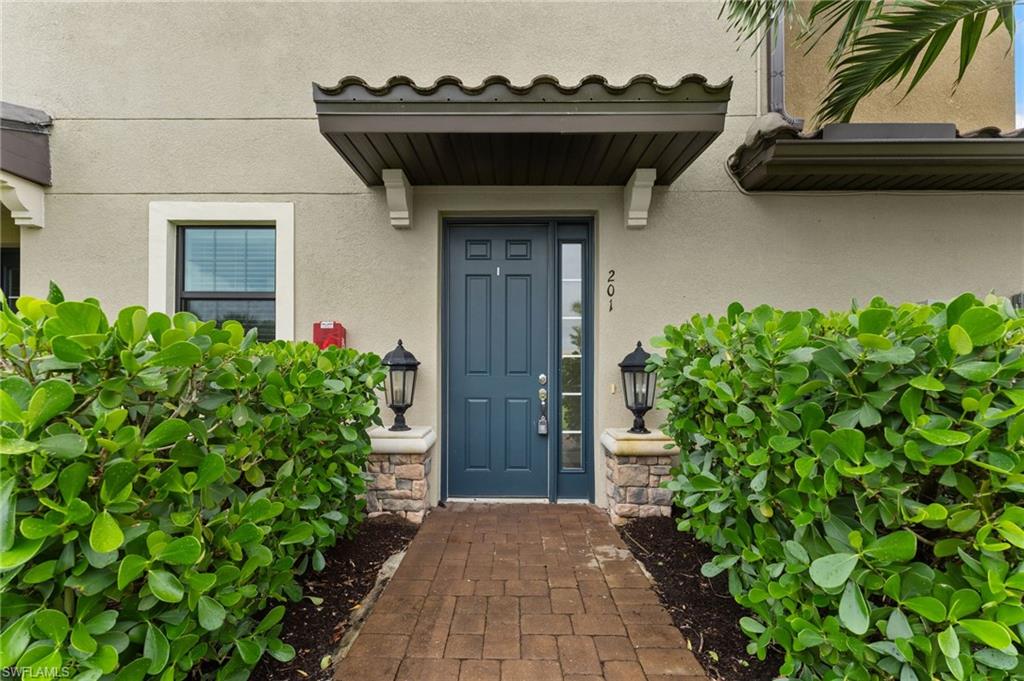 15244 Zeno Way, Unit 201 Naples, FL 34114 - Photo 12 of 48 a front view of a house with a garden