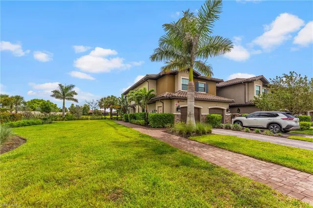 a view of a house with a big yard and large trees