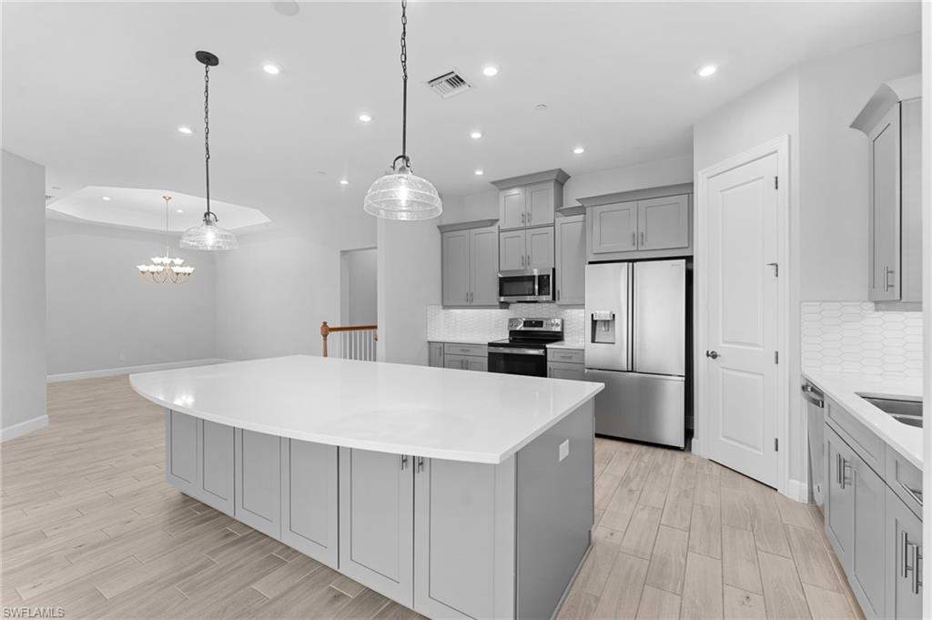 15244 Zeno Way, Unit 201 Naples, FL 34114 - Photo 22 of 48 a large kitchen with stainless steel appliances lots of counter space space refrigerator and a wooden floor