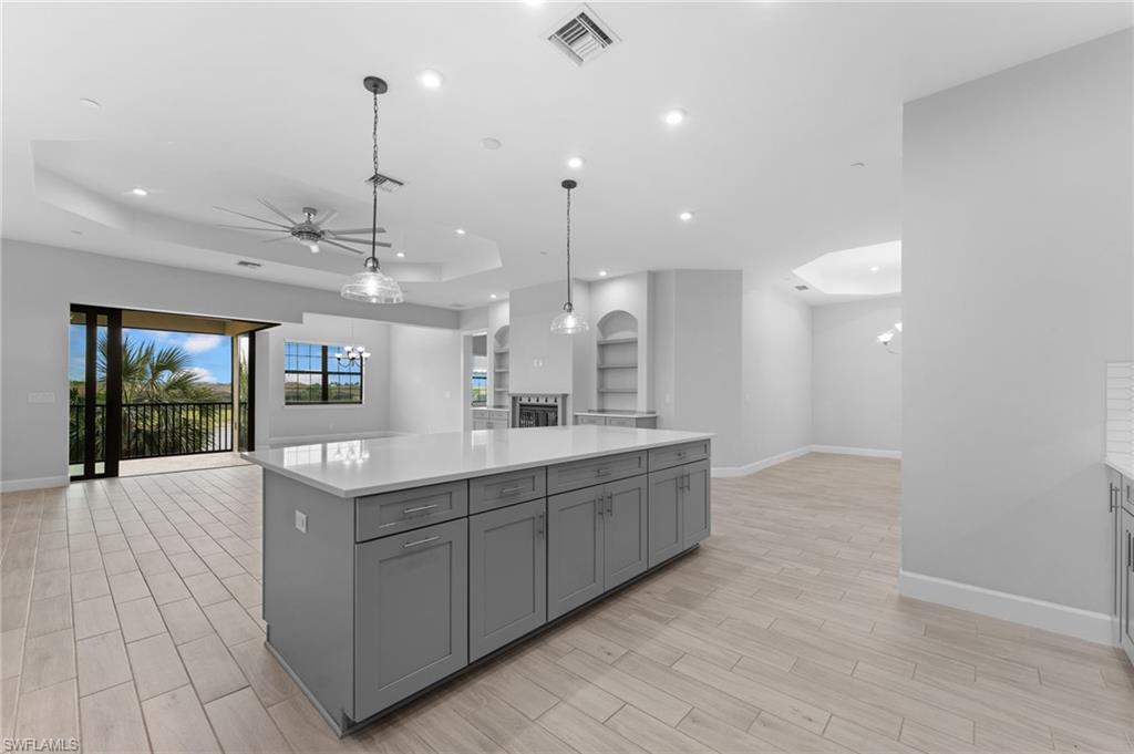 15244 Zeno Way, Unit 201 Naples, FL 34114 - Photo 23 of 48 a large kitchen with kitchen island a large island in it