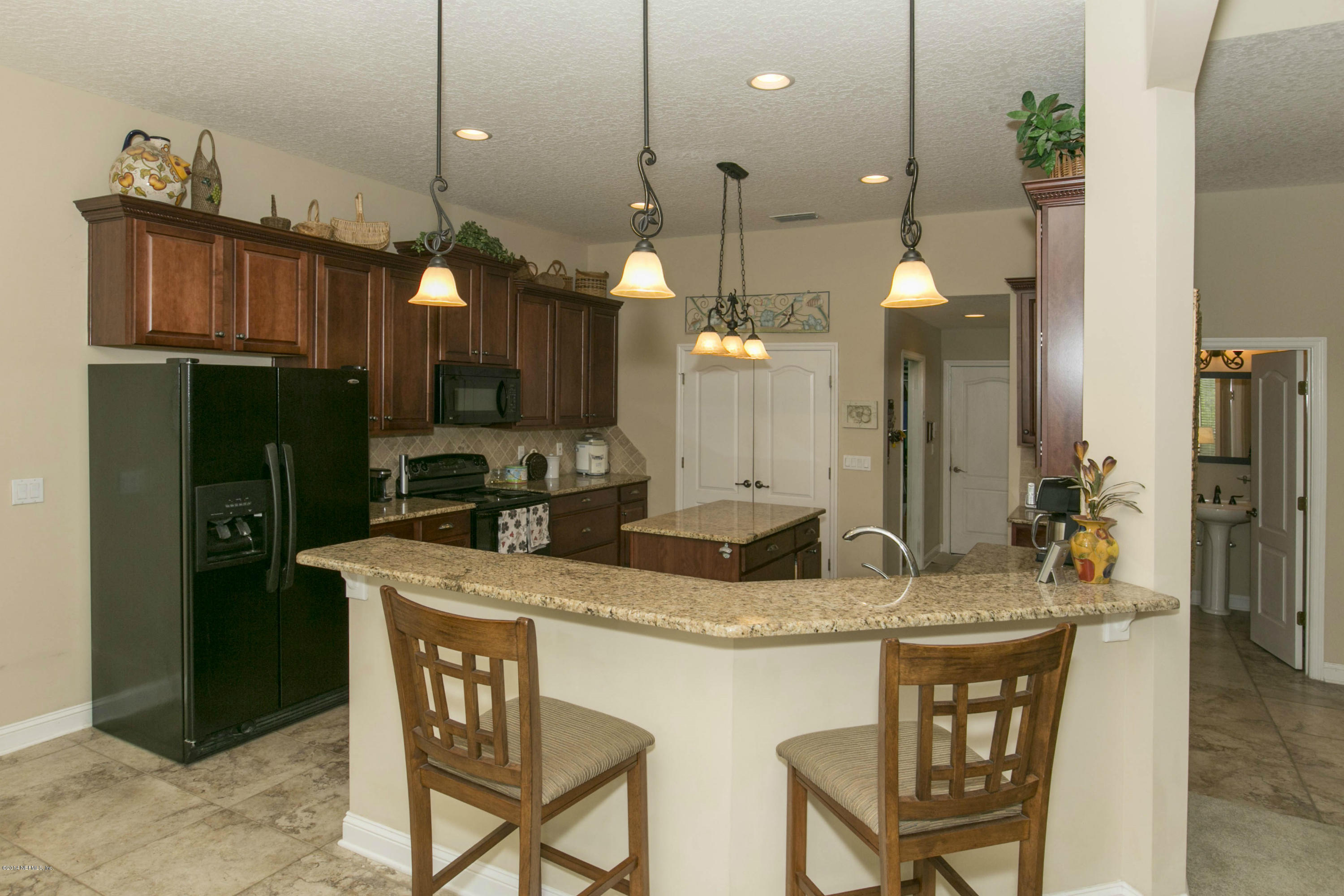 1326 Powis Road St. Augustine, FL 32095 - Photo 6 of 26 a dining table chairs and a refrigerator