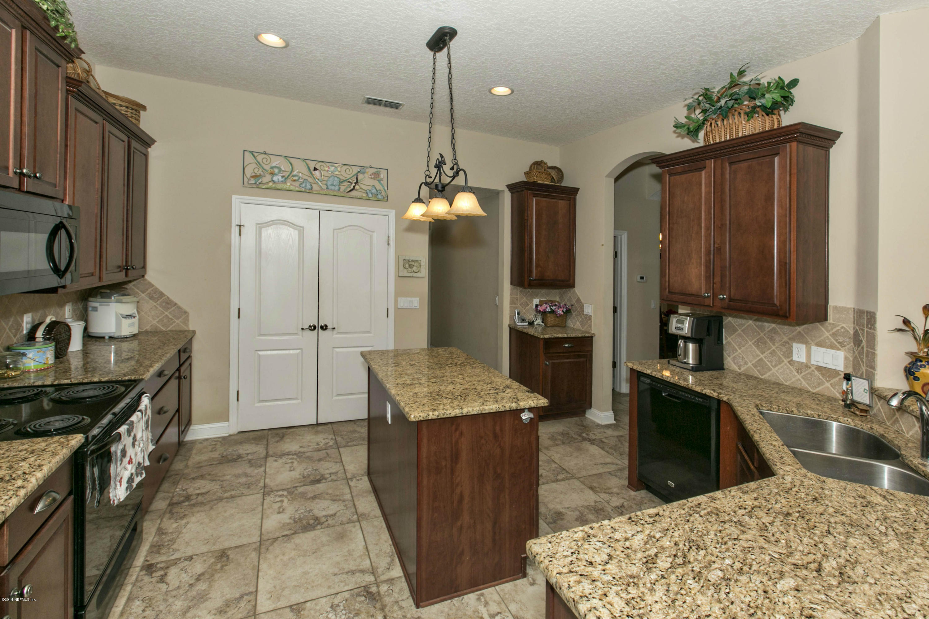 1326 Powis Road St. Augustine, FL 32095 - Photo 7 of 26 a kitchen with stainless steel appliances granite countertop a sink stove and refrigerator