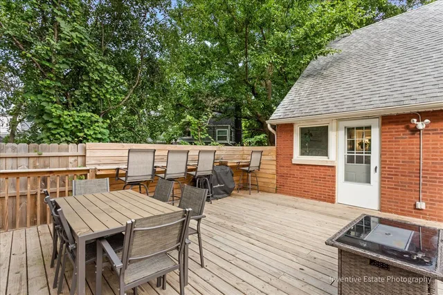a view of a patio with dining table and chairs with wooden floor