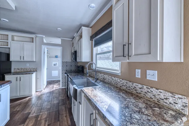 a kitchen with granite countertop a sink and a stove top oven
