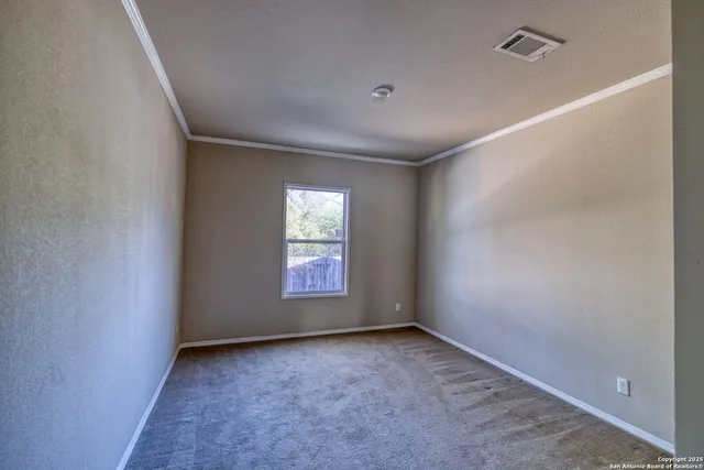 a view of an empty room with window and wooden floor