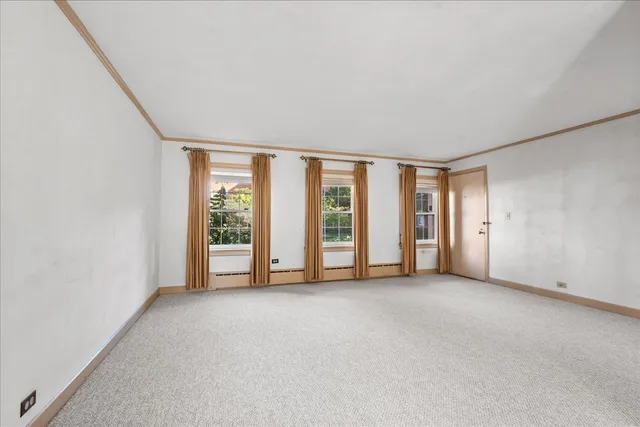an empty room with windows and view of balcony