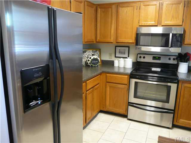 5635 Bridgetowne Way Raleigh, NC 27609 - Photo 2 of 18 a kitchen with granite countertop a refrigerator stove and microwave