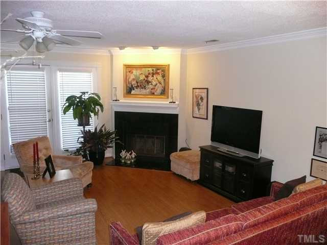 5635 Bridgetowne Way Raleigh, NC 27609 - Photo 5 of 18 a living room with furniture a flat screen tv and a fireplace