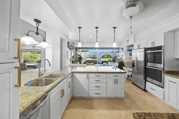 a kitchen with granite countertop a sink stainless steel appliances and cabinets