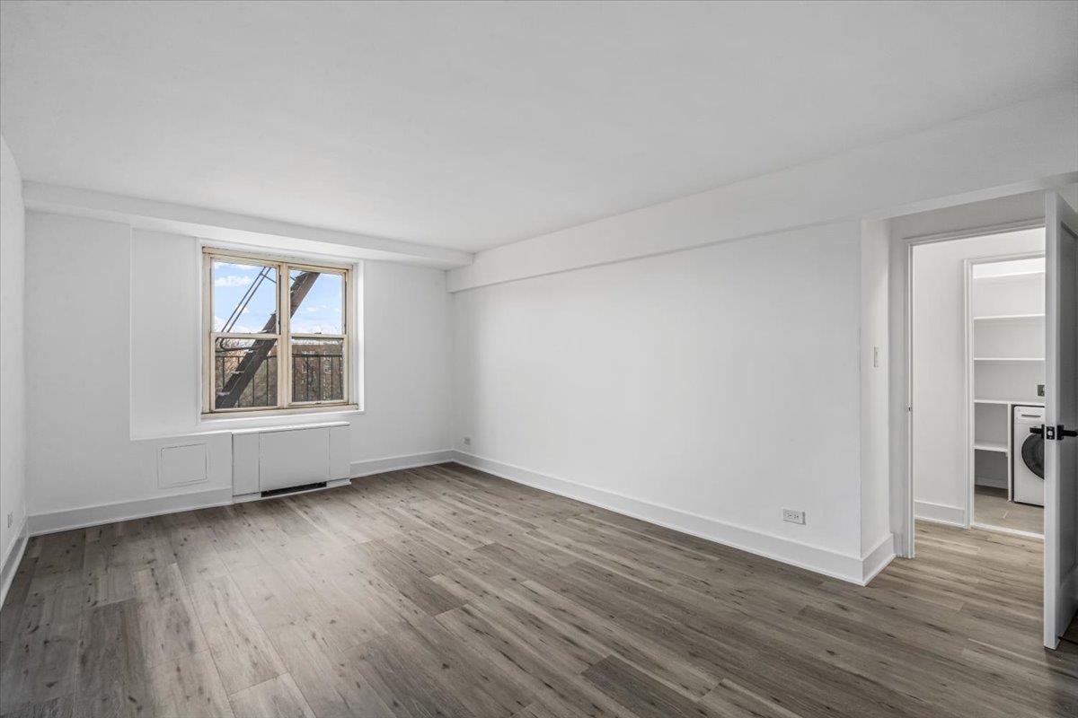 18-65 211th Street, Unit 4C Queens, NY 11360 - Photo 11 of 16 a view of an empty room with wooden floor and a window