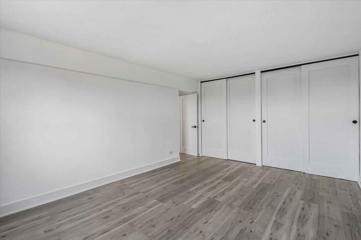 18-65 211th Street, Unit 4C Queens, NY 11360 - Photo 12 of 16 a view of an empty room with wooden floor