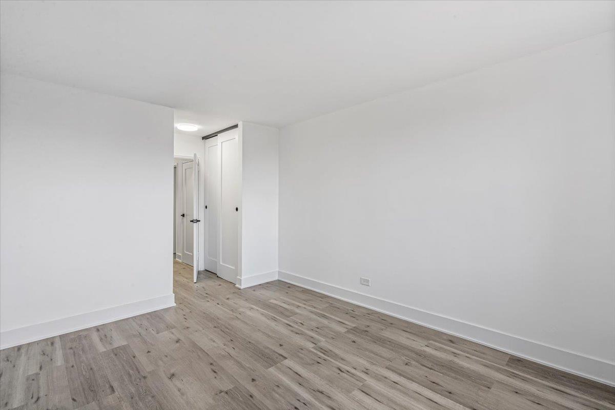 18-65 211th Street, Unit 4C Queens, NY 11360 - Photo 14 of 16 a view of an empty room with wooden floor