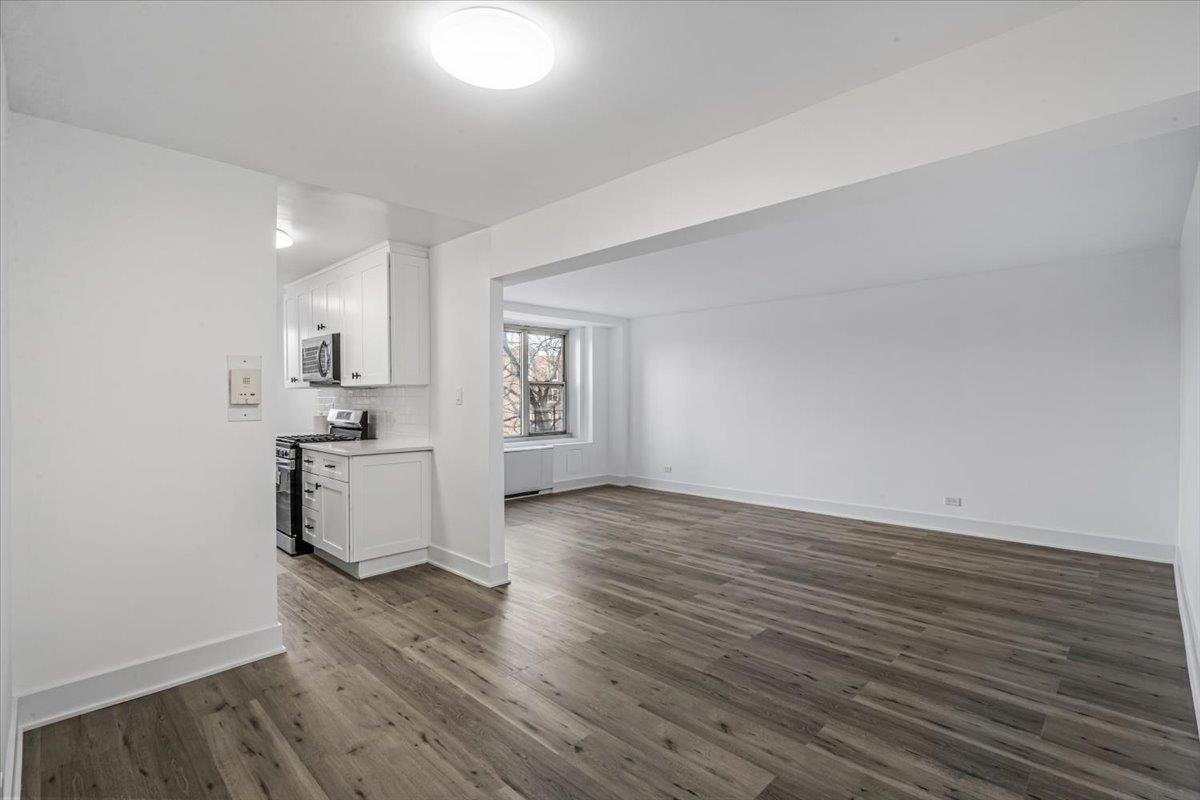 18-65 211th Street, Unit 4C Queens, NY 11360 - Photo 3 of 16 a view of a kitchen cabinets and wooden floor