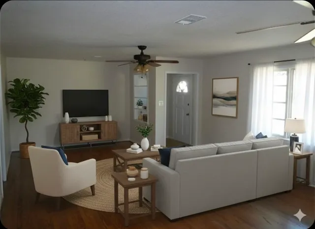a living room with furniture a flat screen tv and a window