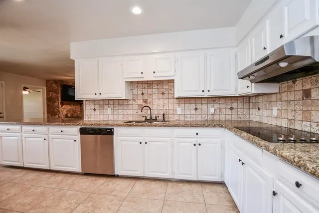 a kitchen with granite countertop white cabinets white stainless steel appliances with a sink and dishwasher