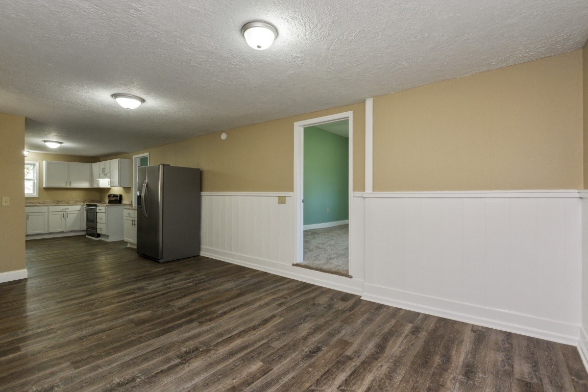 2480 Mann Road Lebanon, TN 37087 - Photo 17 of 35 an empty room with wooden floor kitchen view and a window