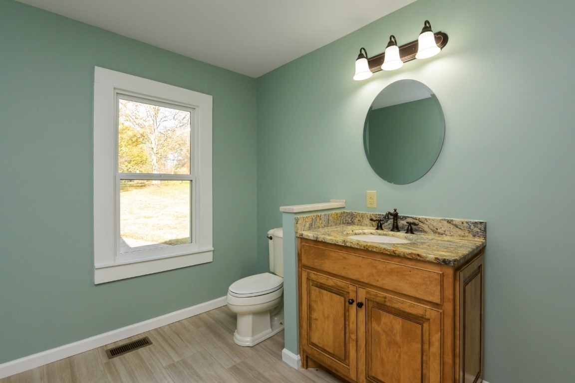 2480 Mann Road Lebanon, TN 37087 - Photo 30 of 35 a bathroom with a toilet sink vanity and mirror
