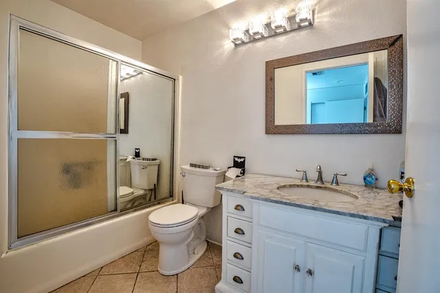 a bathroom with a granite countertop sink toilet and shower