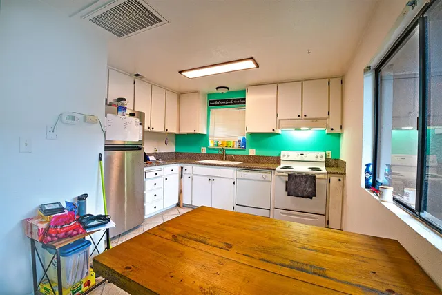 a kitchen with stainless steel appliances kitchen island granite countertop a refrigerator sink and cabinets