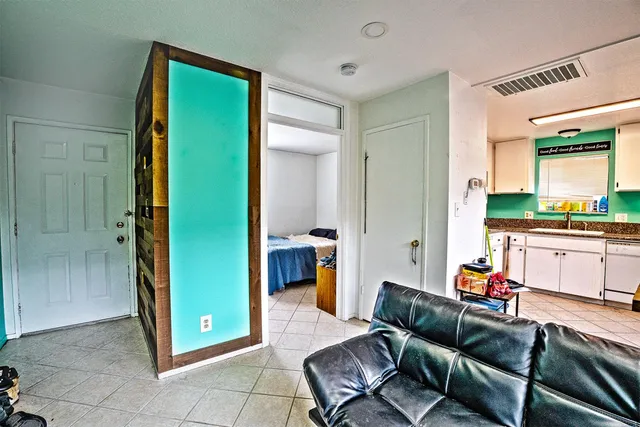 a living room with furniture and a open kitchen view