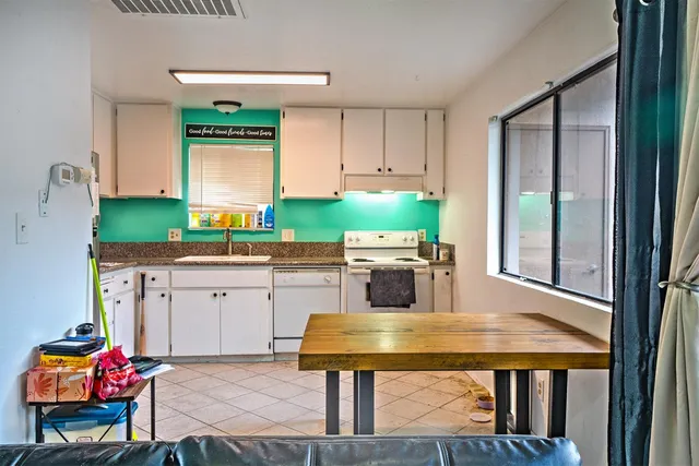 a kitchen with stainless steel appliances kitchen island granite countertop a sink dishwasher and cabinets with wooden floor