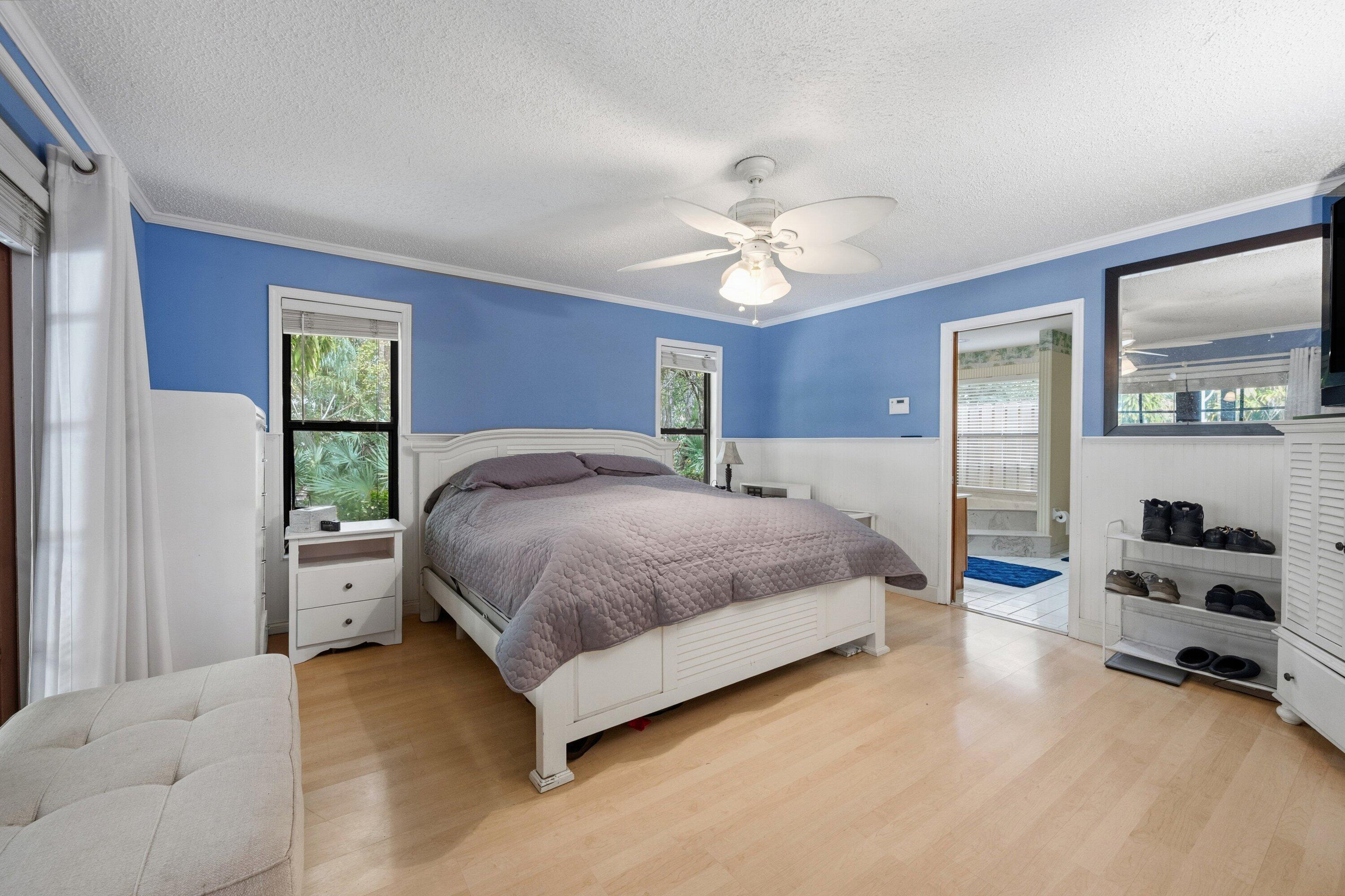 7169 154th Road North Palm Beach Gardens, FL 33418 - Photo 20 of 62 a spacious bedroom with a bed and a view of walk in closet