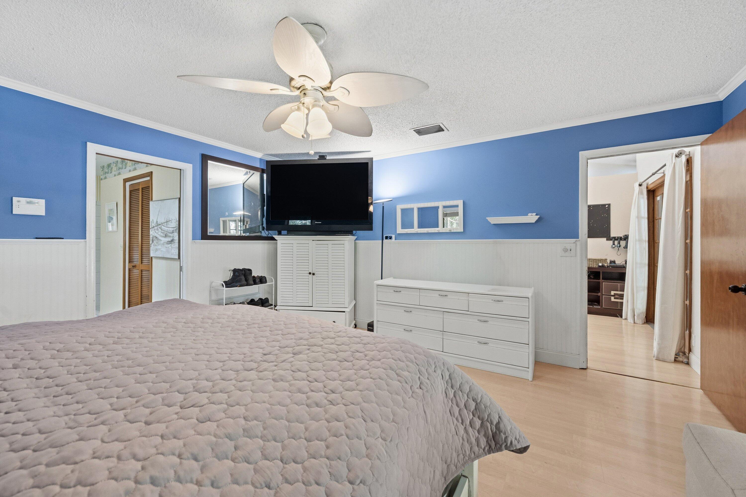 7169 154th Road North Palm Beach Gardens, FL 33418 - Photo 21 of 62 a bedroom with a bed and a flat screen tv