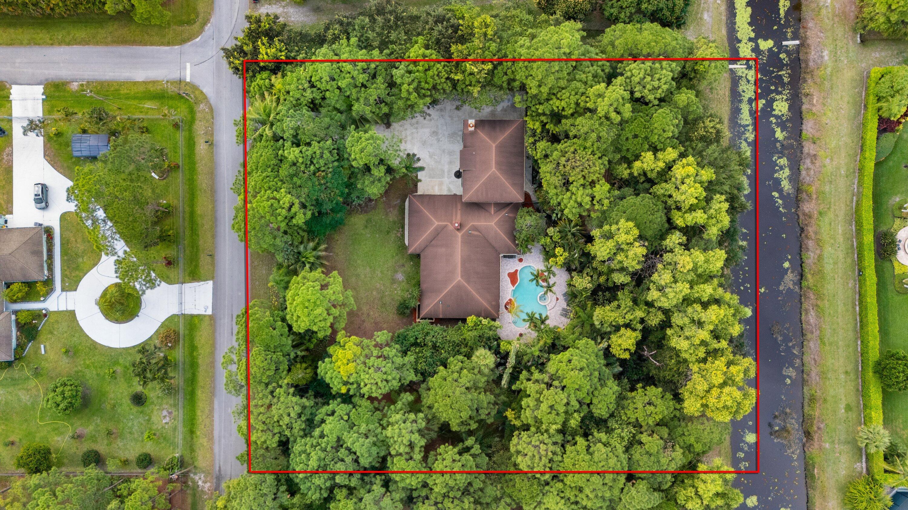 7169 154th Road North Palm Beach Gardens, FL 33418 - Photo 3 of 62 an aerial view of residential house with outdoor space and trees all around