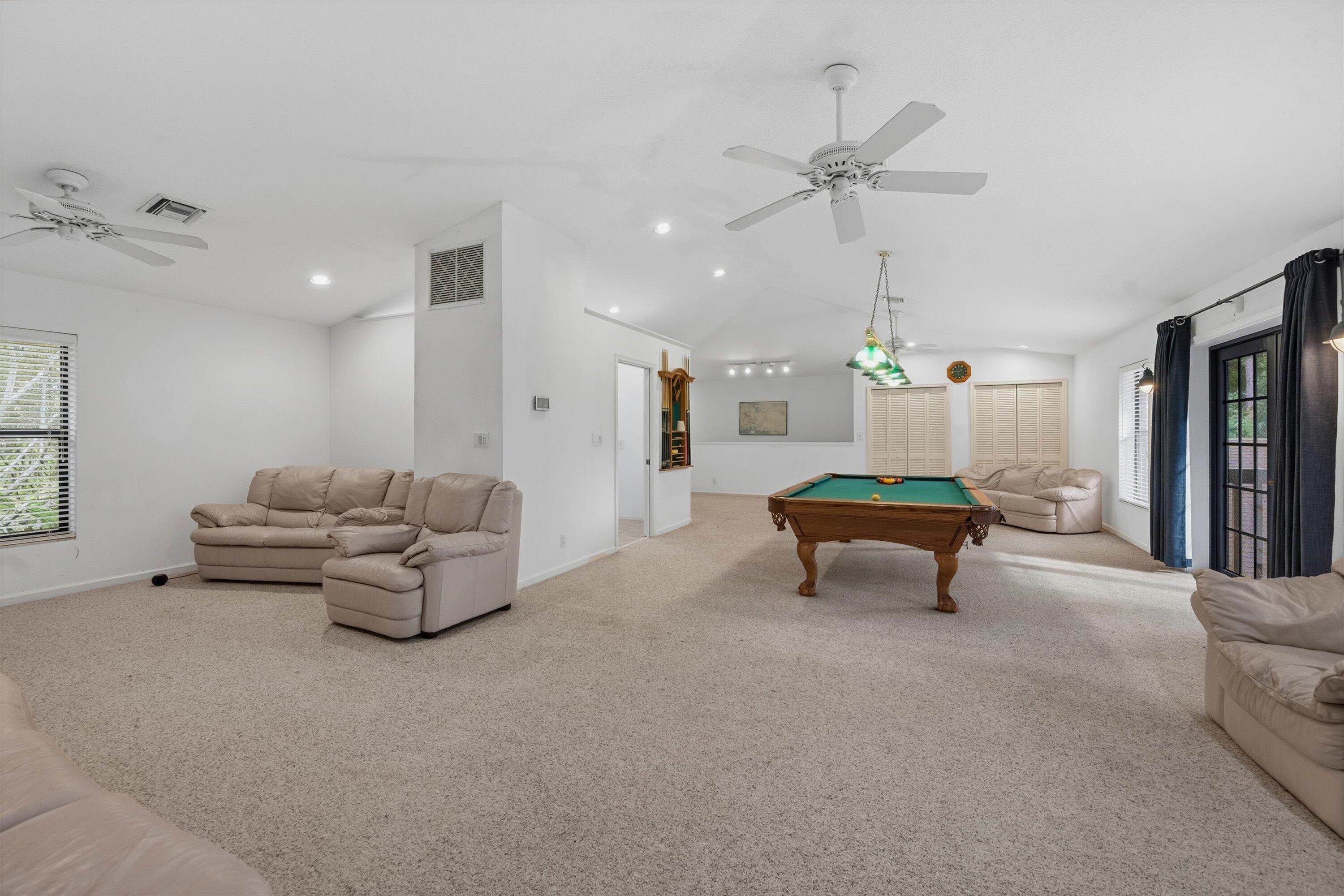 7169 154th Road North Palm Beach Gardens, FL 33418 - Photo 36 of 62 a living room with furniture and a chandelier