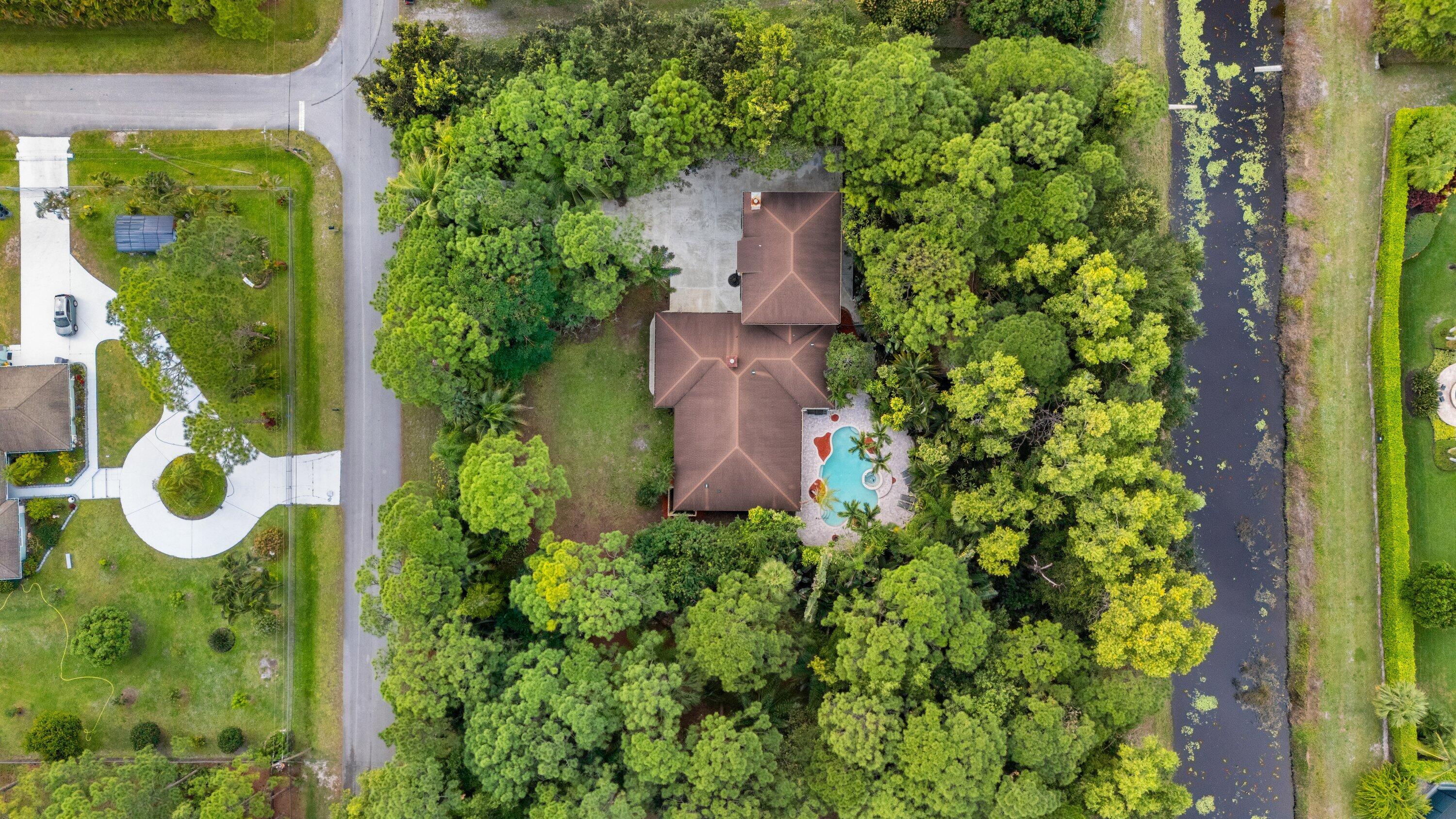 7169 154th Road North Palm Beach Gardens, FL 33418 - Photo 50 of 62 an aerial view of residential house with outdoor space and trees all around