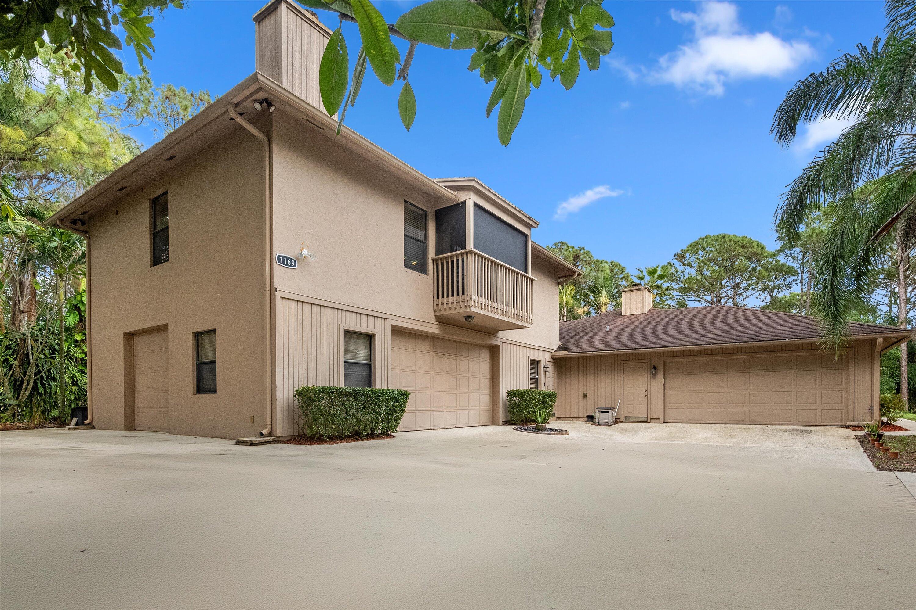 7169 154th Road North Palm Beach Gardens, FL 33418 - Photo 5 of 62 a front view of a house with a yard and garage
