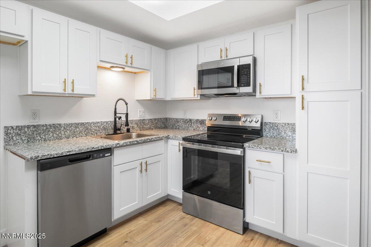 2136 Roundhouse Road Sparks, NV 89431 - Photo 7 of 26 a kitchen with stainless steel appliances granite countertop a sink stove and microwave