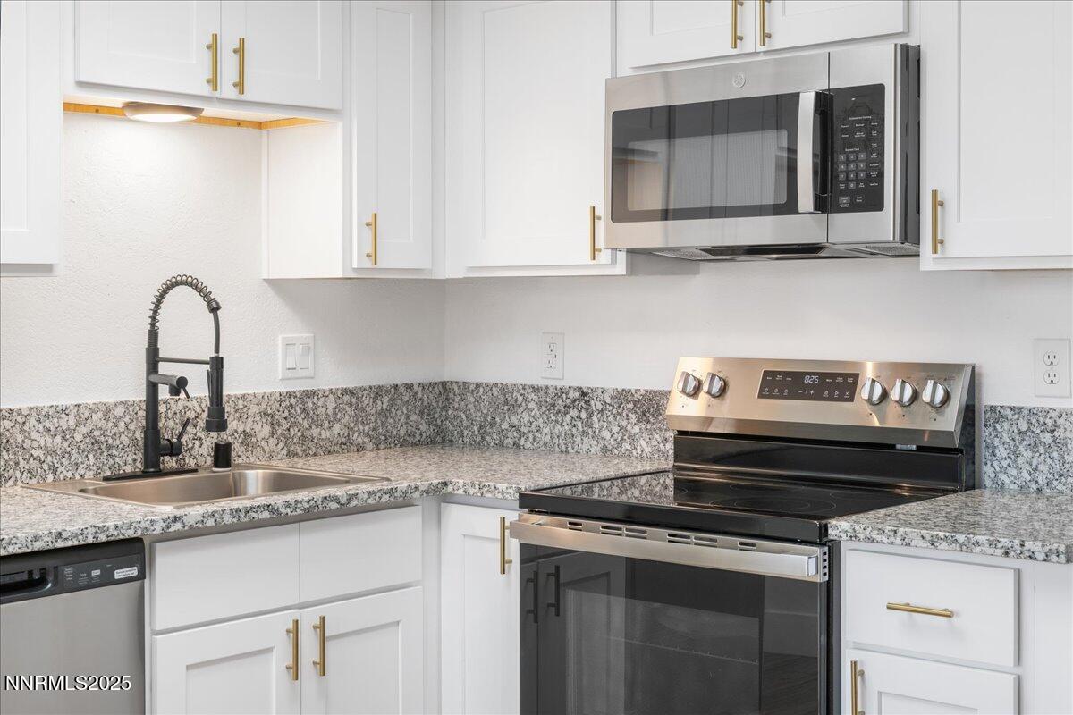 2136 Roundhouse Road Sparks, NV 89431 - Photo 9 of 26 a kitchen with stainless steel appliances granite countertop a sink stove and microwave