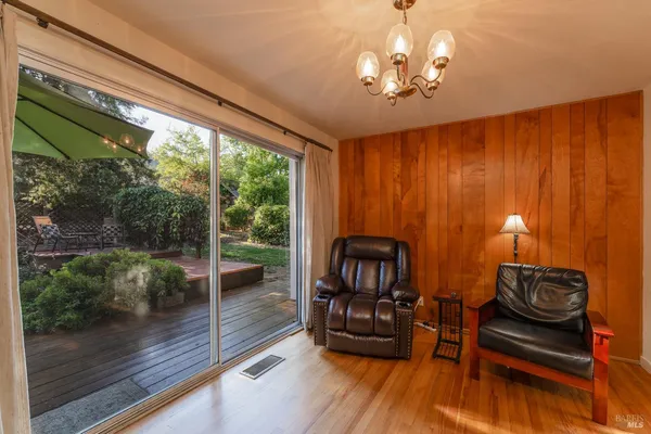 a view of a livingroom with furniture wooden floor and next to a window