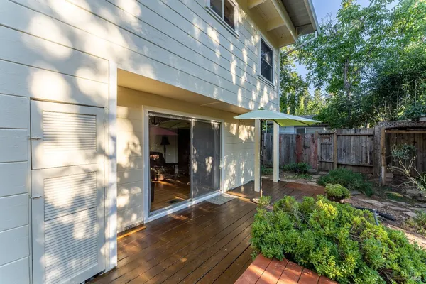 a view of a patio with table and chairs and wooden fence