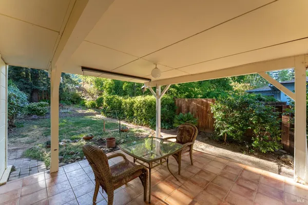 a view of a patio with table and chairs potted plants with floor to ceiling window