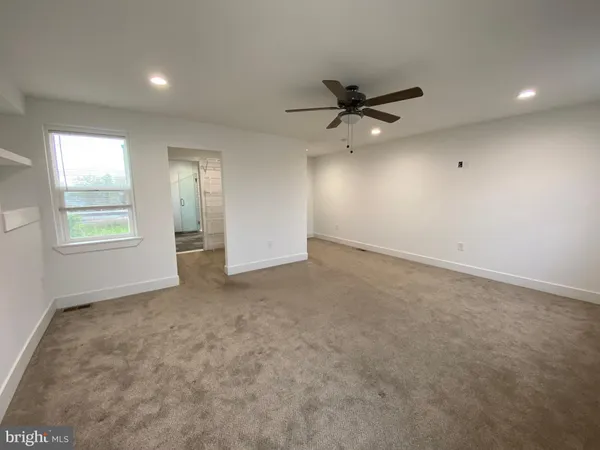 an empty room with windows and ceiling fan
