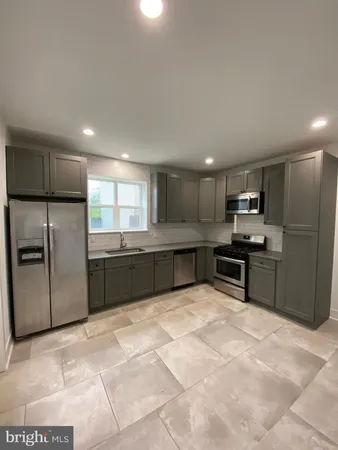 a large kitchen with a refrigerator and a stove top oven