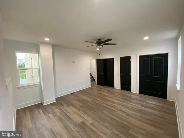 a view of an empty room with window and closet area