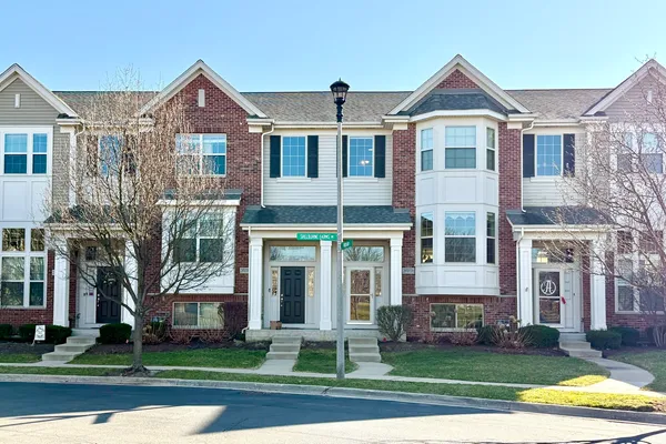 front view of a brick house with a yard
